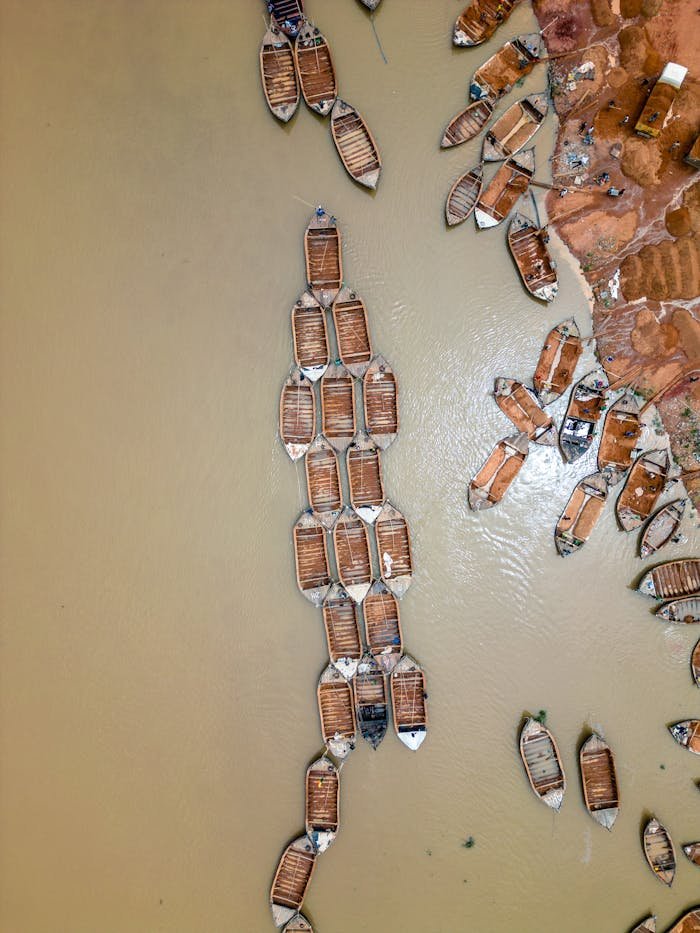 Discover a unique aerial perspective of boats lining the riverbank in Bamako, Mali.