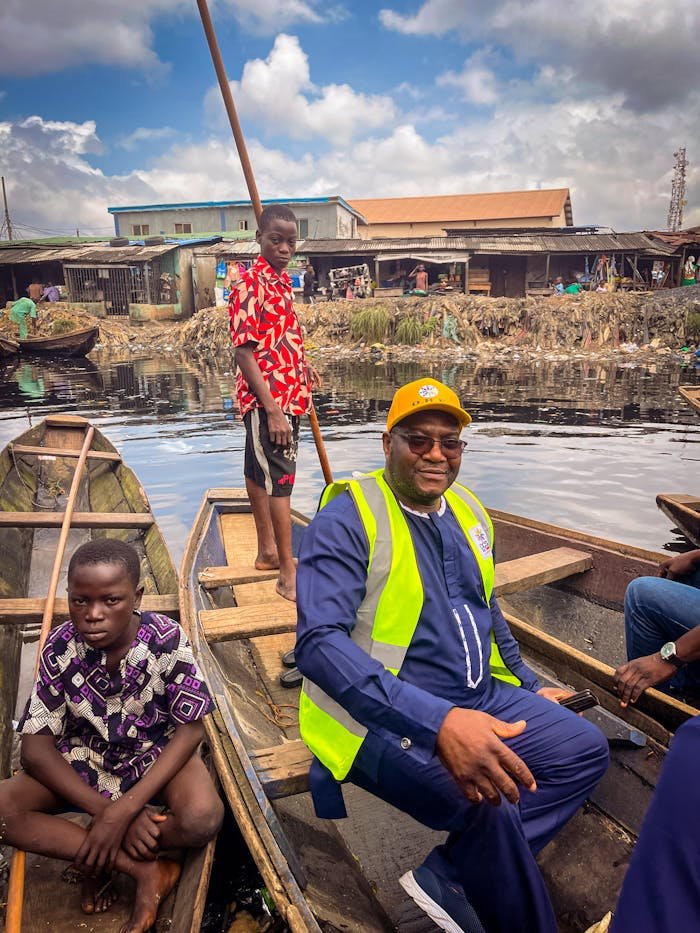 Lively scene of canoe riders navigating a Lagos waterway, showcasing vibrant local life and culture.