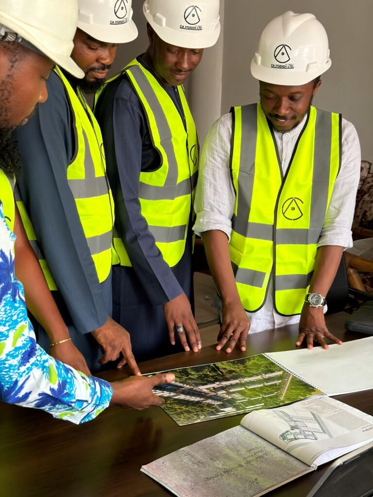 Good Governance and Leadership A group of engineers discussing building plans at an indoor office table.